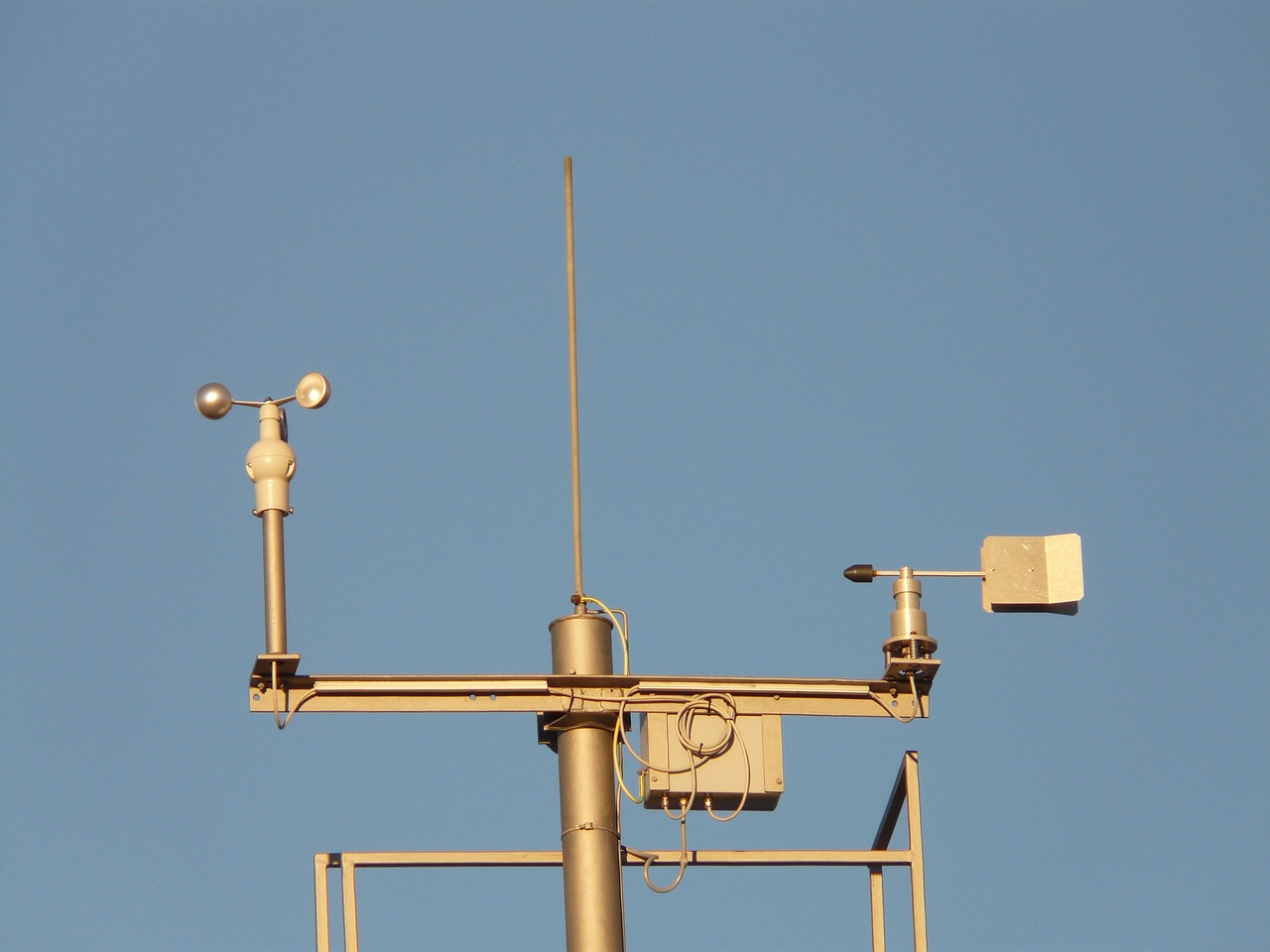 A weather station stands against a blue sky.